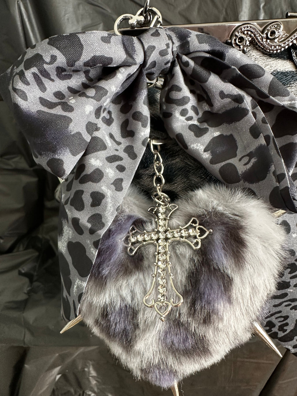 Detail of heart-shaped charm and decorative cross